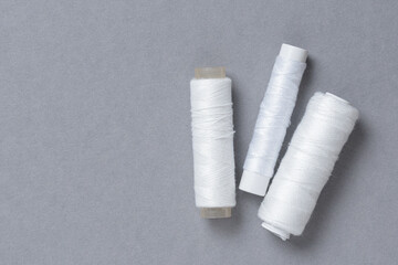 White thread spools background with copy space for text close-up flat lay top view