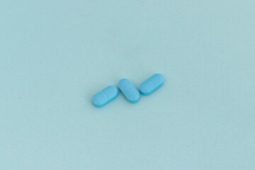 Closeup of a blue pills on blue background with copy space