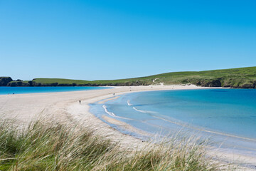 St Ninian's Beach with crystal-clear water and a blue sky in Shetland