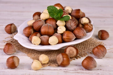 Obraz premium Hazelnuts in a plate on a white background.Close-up. 