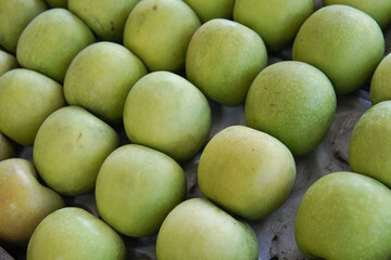 Fresh green apples are displayed in a fruit shop. This photo is ideal for use in poster designs, greeting cards, or as an illustration for articles about fruits.