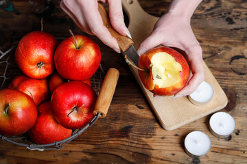 Florist at work: woman shows how to make a Christmas decoration with apple, candle and branches of fir. Step by step, tutorial.
