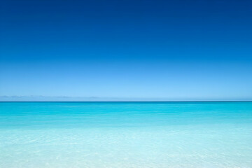 Fototapeta premium A serene beach scene with clear turquoise water and a bright blue sky.