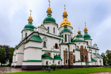 A large white and green building with gold domes and crosses