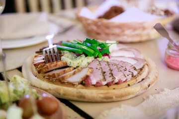 A plate of food with a variety of meats and vegetables on a wooden board