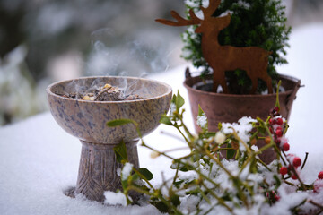 Incense ritual in winter on the terrace – burning resins and herbs on glowing charcoal. Shot...