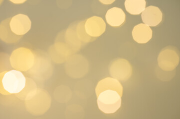 Abstract bokeh texture background with orange and yellow circles from a garland on a blured backdrop close up.