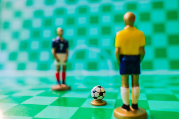 Soccer strategy concept with miniature referee and players on checkered field, tactical game setup