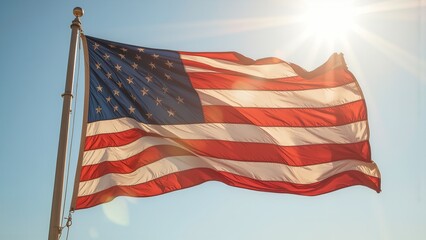 American flag waving in sunlight with blue sky.