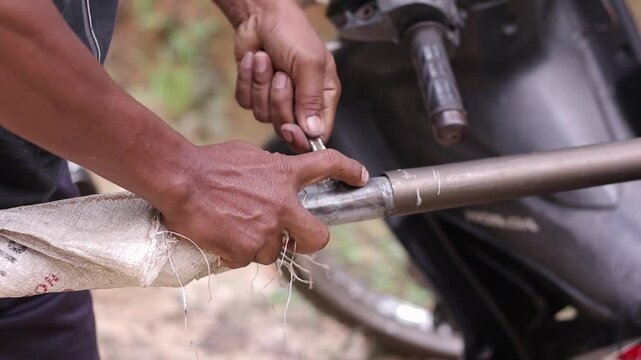 Close up of hands holding palm oil harvesting tools