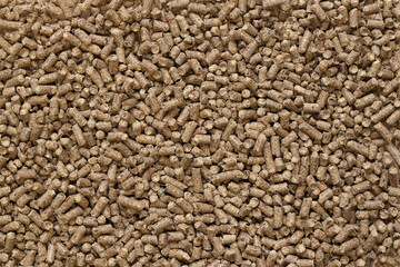 Wood filler for cat toilet, top view. Hygienic filler for pets. Pressed wood, large granules. Pellets. A pile of wood granules. Filler for dogs, cats, domestic rodents. Texture