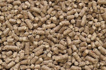 Wood filler for cat toilet, top view. Hygienic filler for pets. Pressed wood, large granules. Pellets. A pile of wood granules. Filler for dogs, cats, domestic rodents. Texture