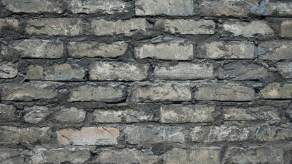 The photo shows a close-up of a grey brick wall