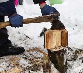 male hand chopping wood with an ax.