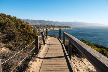 Obraz premium Wood boardwalk hiking trail above remote Dume Cove beach in Malibu, California.