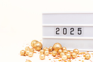 2025 New Year concept with place for text. Lightbox with numbers and shiny confetti in front of beige background.