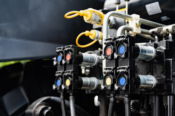 Close-up of hydraulic connectors and valves on industrial equipment.