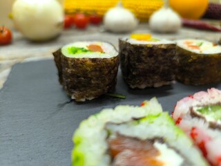 Delicious sushi rolls on a granite chopping board.