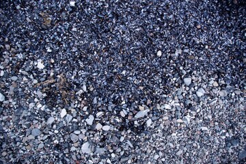 Draufsicht auf Kies und Muscheln, die einen strukturierten natürlichen Hintergrund in einer malerischen deutschen Umgebung schaffen