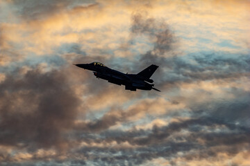 F-16 Silhouette at Sunset. A Polish Air Force F-16 fighter jet cuts through the dramatic sunset sky...
