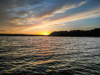 Sunset Over a Tranquil Lake in Poland. A serene sunset view over a calm lake in Poland, with golden...