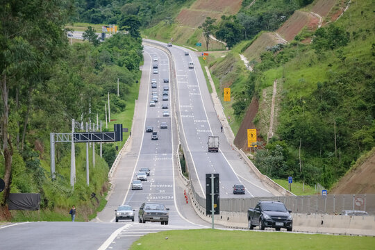 Transito de veiculos intenso na rodovia dos tamoios litoral norte da praia com fundo de natureza e represas.