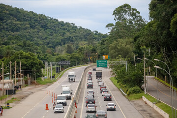 Transito de veiculos intenso na rodovia dos tamoios litoral norte da praia com fundo de natureza e...