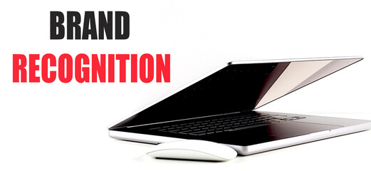 Text brand recognition with a partially open laptop and a white mouse on a white background