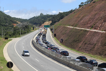 Transito de veiculos intenso na rodovia dos tamoios litoral norte da praia com fundo de natureza e...