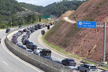 Transito de veiculos intenso na rodovia dos tamoios litoral norte da praia com fundo de natureza e...