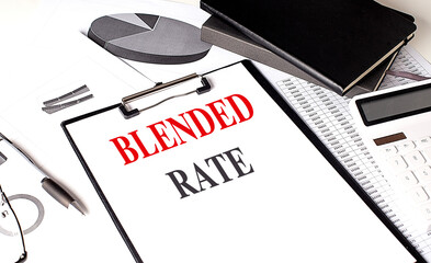 Clipboard with the text blended rate, charts, notebook, pen, and calculator on a desk
