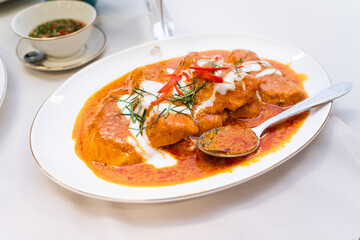Thick Thai curry with stewed pork and herbs and spices isolated on white