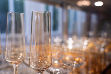 Many empty champagne glasses on a bar, on a blurred background