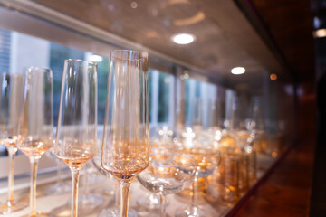 Many empty champagne glasses on a bar, on a blurred background