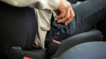 Hand holding seat belt before fastening in car