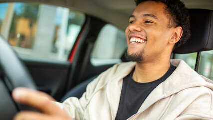 Man smiling while driving in urban setting