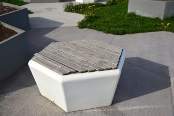 a hexagon bench with wooden panels isolated in the park close up