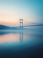 Obraz premium Bosphorus Strait at sunrise, with the Istanbul Bridge casting a long shadow across the water.