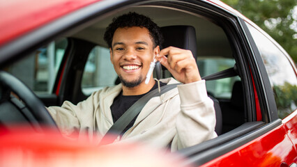 Obraz premium Smiling man with car keys in red car