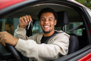 Smiling man in car holding keys through window