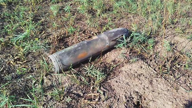 Unexploded shells lie on the ground. Large aerial bombs lie in the crater from the explosion. High quality