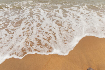 Calm beach with gentle waves and soft sand.