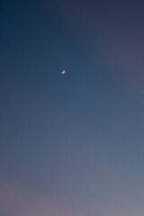 Serene night sky with a crescent moon visible.