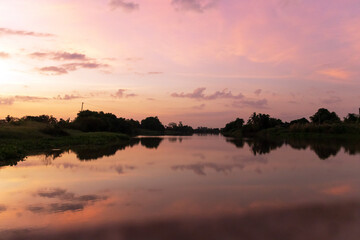 Tranquil river at sunset with a vibrant sky.