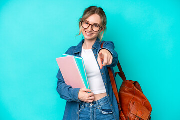 Young student woman isolated on blue background pointing front with happy expression
