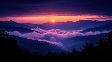 Obraz premium Vibrant sunset over misty mountain range.