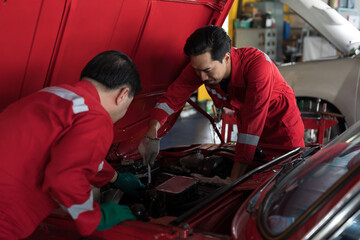 Group of Asian male mechanic maintenance engine car at auto repair shop. Male technician repairing...