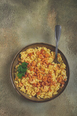 risotto with shrimp, in a bowl, on a textured surface, with a side dish of fresh coriander, homemade, no people,