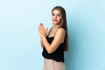Young Uruguayan woman isolated on blue background scheming something