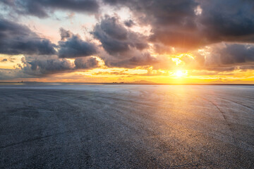 Asphalt road square and coastline with beautiful sky clouds nature landscape at sunset. Outdoor asphalt parking lot.